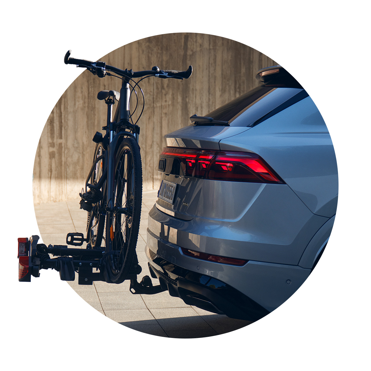 Nahaufnahme eines Fahrradträgers mit montiertem Fahrrad am Heck eines grauen Audi.